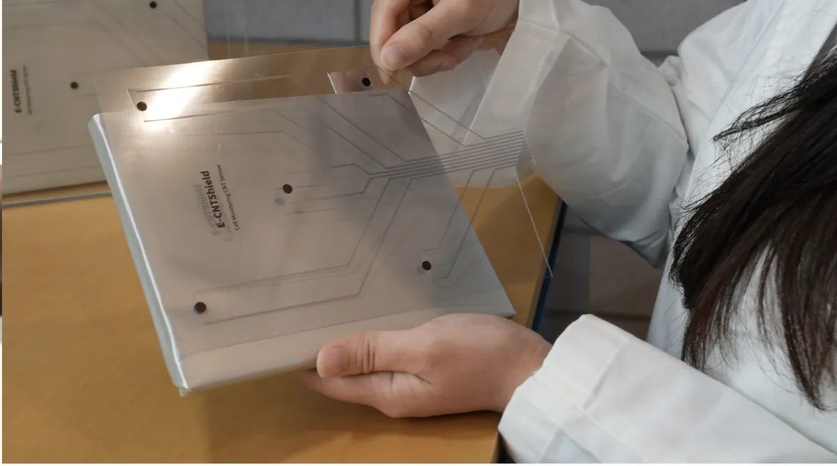 E-CNTShield sheet being attached to a battery cell surface